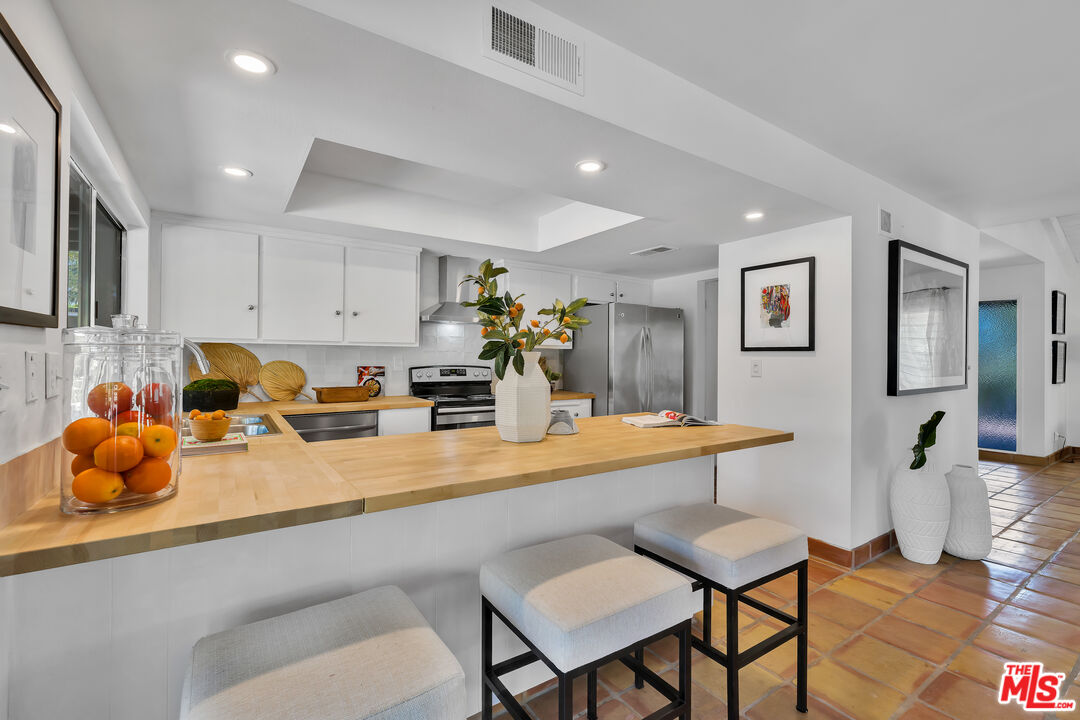 73589 Haystack Road Palm Desert, CA 92260 - Photo 16 of 54 a kitchen with a sink refrigerator and cabinets