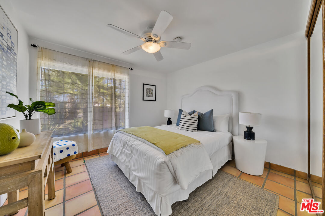 73589 Haystack Road Palm Desert, CA 92260 - Photo 21 of 54 a bedroom with a bed and a chandelier