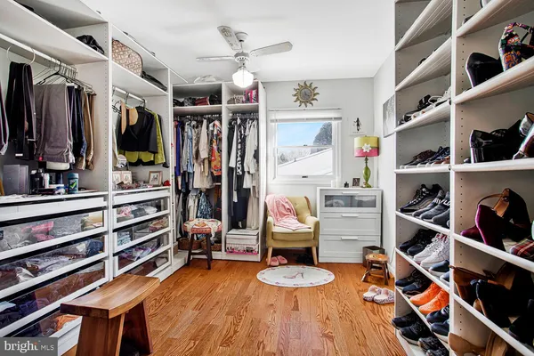 a view of walk in closet with clothes and shoes