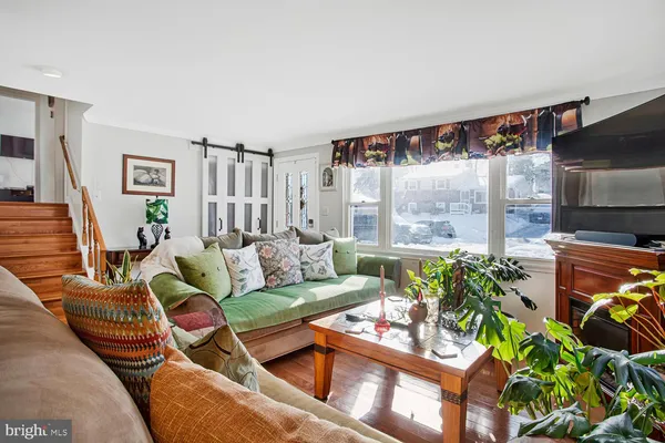 a living room with furniture a floor to ceiling window and a flat screen tv