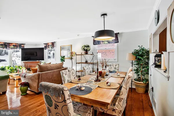 a dining room with furniture a chandelier and wooden floor