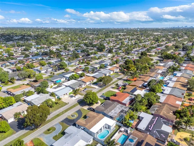 an aerial view of residential houses with outdoor space and ocean view