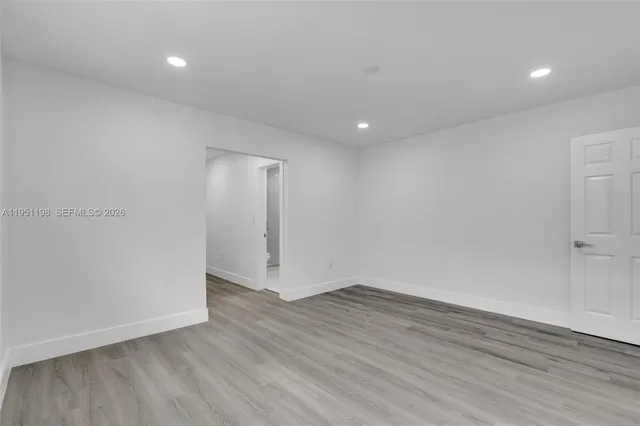 a view of an empty room with wooden floor