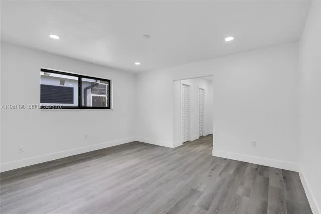 a view of a room with wooden floor and window