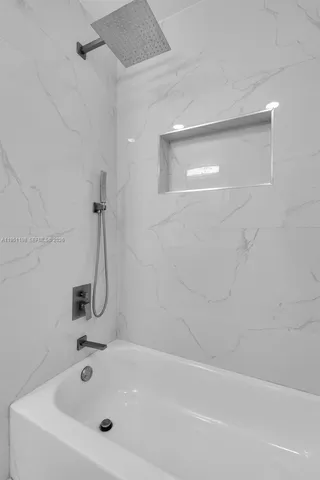 a white bath tub sitting next to a white sink and vanity