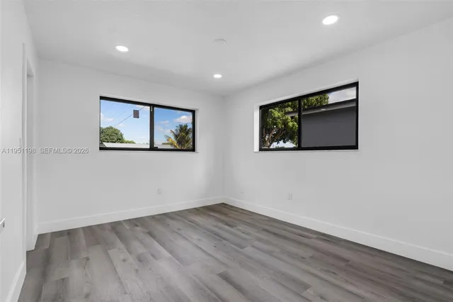 a view of empty room with wooden floor