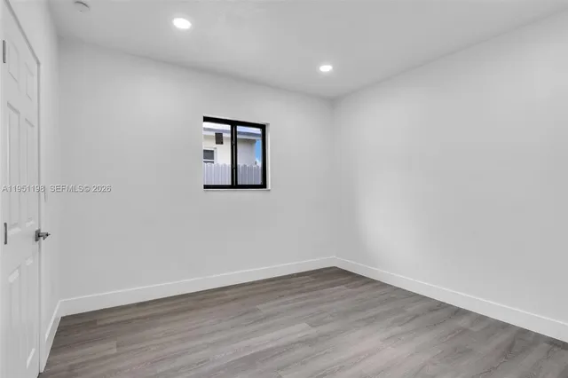 a view of a room with wooden floor and window