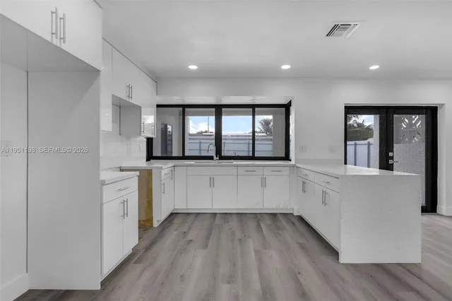 a kitchen with white cabinets and white appliances
