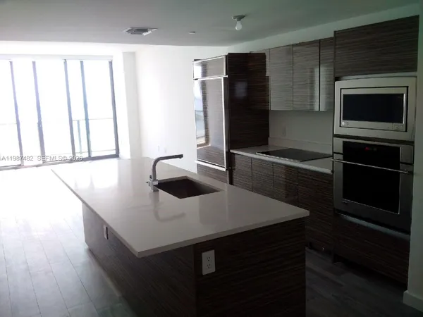 a kitchen with stainless steel appliances a microwave a sink and cabinets