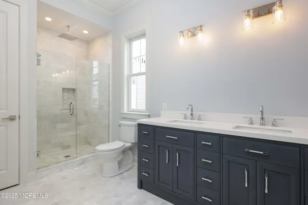 a bathroom with a double vanity sink mirror and toilet