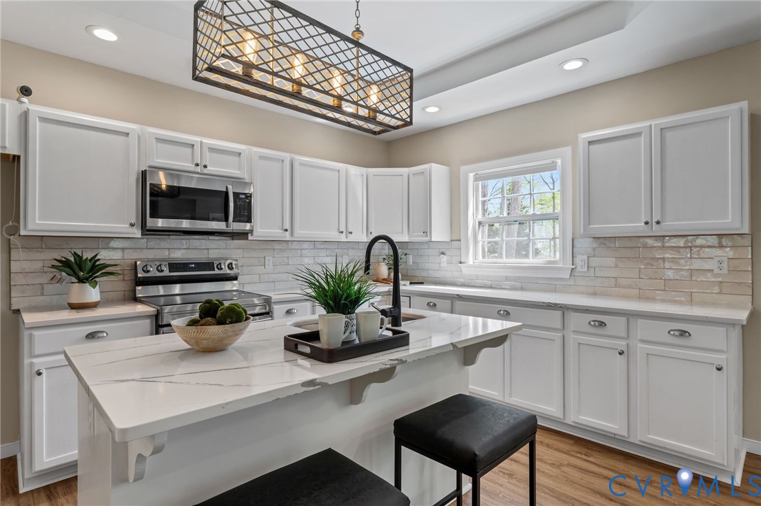 2701 Perdue Avenue Chester, VA 23831 - Photo 11 of 54 a kitchen with stainless steel appliances granite countertop a sink a stove a microwave a refrigerator cabinets and a window