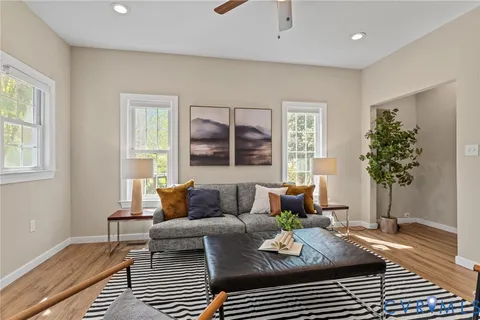 a living room with furniture a rug and white walls