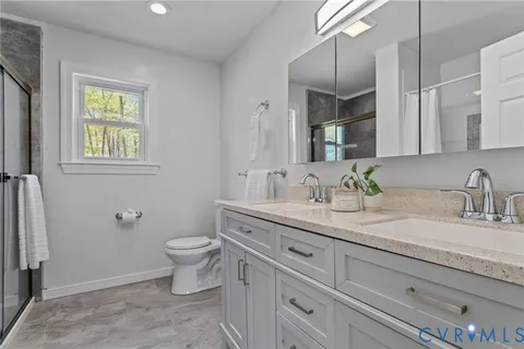 a spacious bathroom with a tub sink double vanity and hallway
