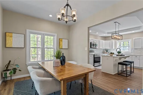 a view of a dining room with furniture a chandelier and wooden floor