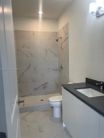 a white toilet sitting next to a white sink