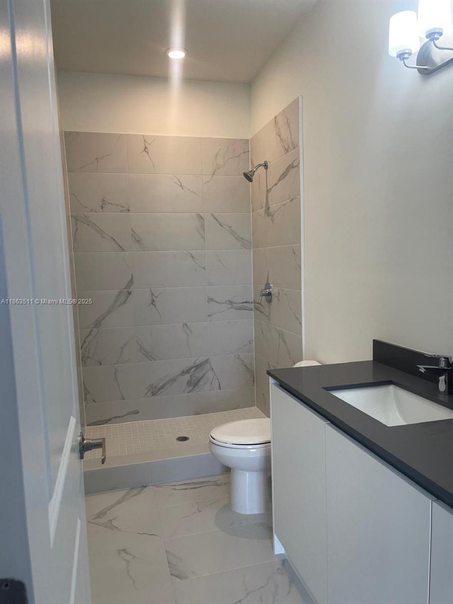 18988 Southwest 344th Terrace Homestead, FL 33034 - Photo 26 of 28 a bathroom with a granite countertop sink toilet and shower