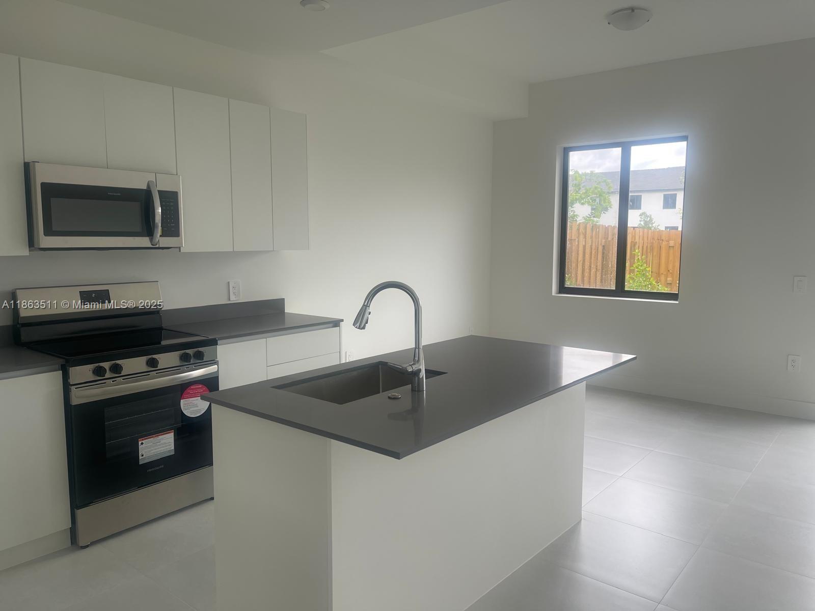 18988 Southwest 344th Terrace Homestead, FL 33034 - Photo 4 of 28 a kitchen with a stove and a sink