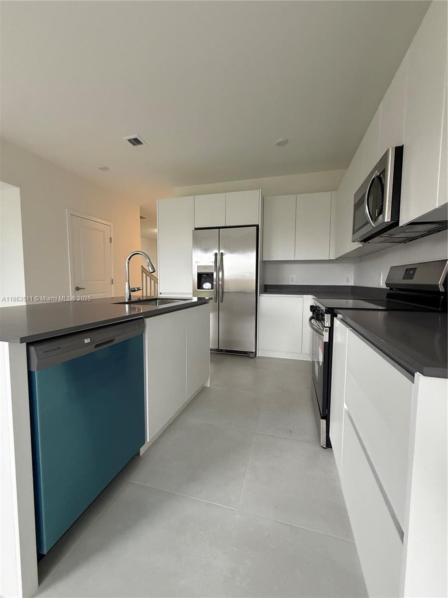 18988 Southwest 344th Terrace Homestead, FL 33034 - Photo 5 of 28 a kitchen with stainless steel appliances granite countertop a sink and a refrigerator