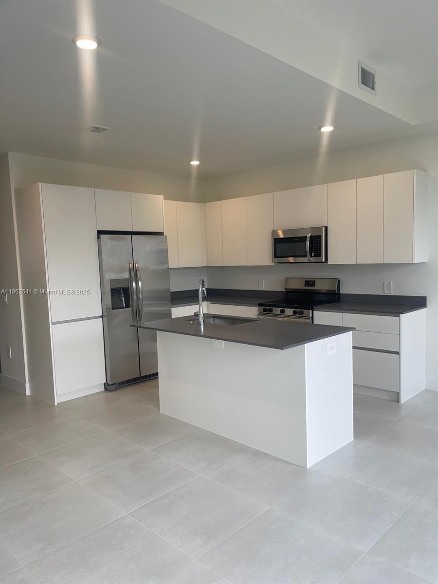 18988 Southwest 344th Terrace Homestead, FL 33034 - Photo 7 of 28 a kitchen with stainless steel appliances a refrigerator a stove top oven and a sink