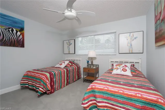 a bedroom with two beds lamp and a chandelier