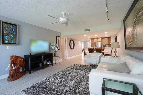a living room with furniture a couch and a mirror