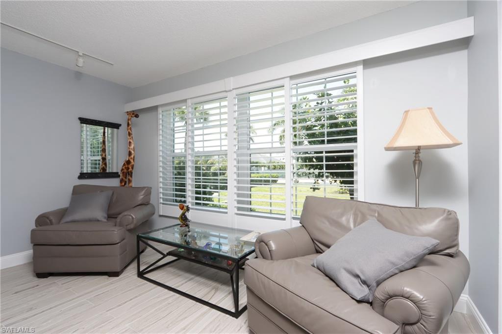 4200 Belair Lane, Unit 114 Naples, FL 34103 - Photo 4 of 22 a living room with furniture and a large window