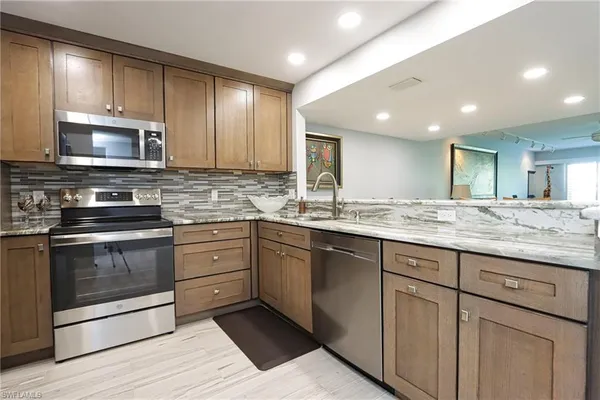 a kitchen with granite countertop cabinets stainless steel appliances and a counter space