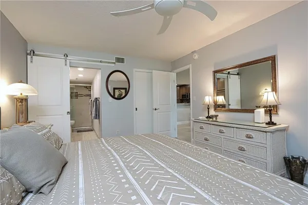 a spacious bedroom with a bed and a chandelier