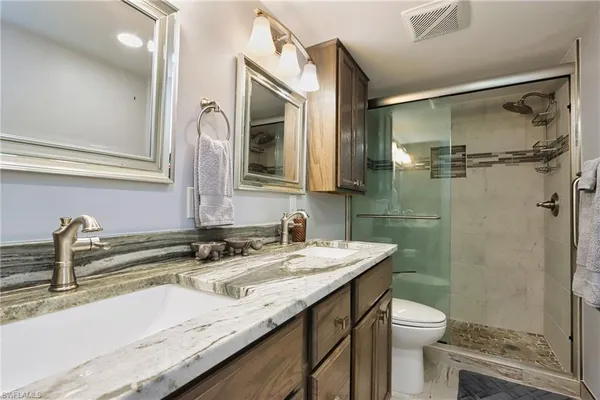 a bathroom with a granite countertop sink toilet and shower