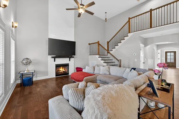 a living room with furniture a flat screen tv and a fireplace