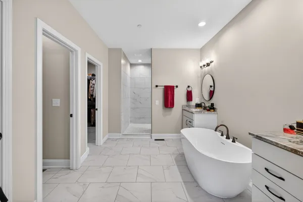 a bathroom with a tub sink and mirror