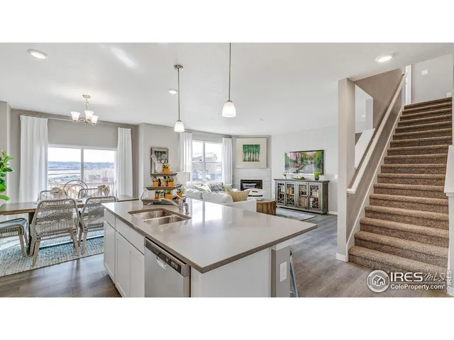 a kitchen with a stove a refrigerator a dining table and chairs with wooden floor