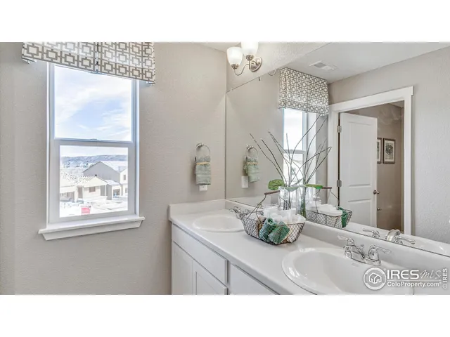 a bathroom with a sink mirror and a window