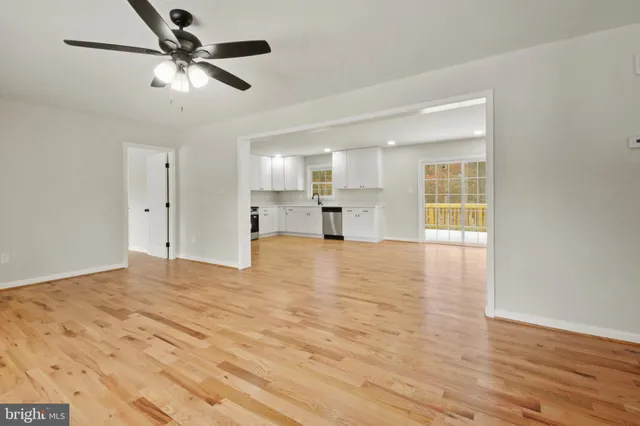 a view of empty room with wooden floor and window