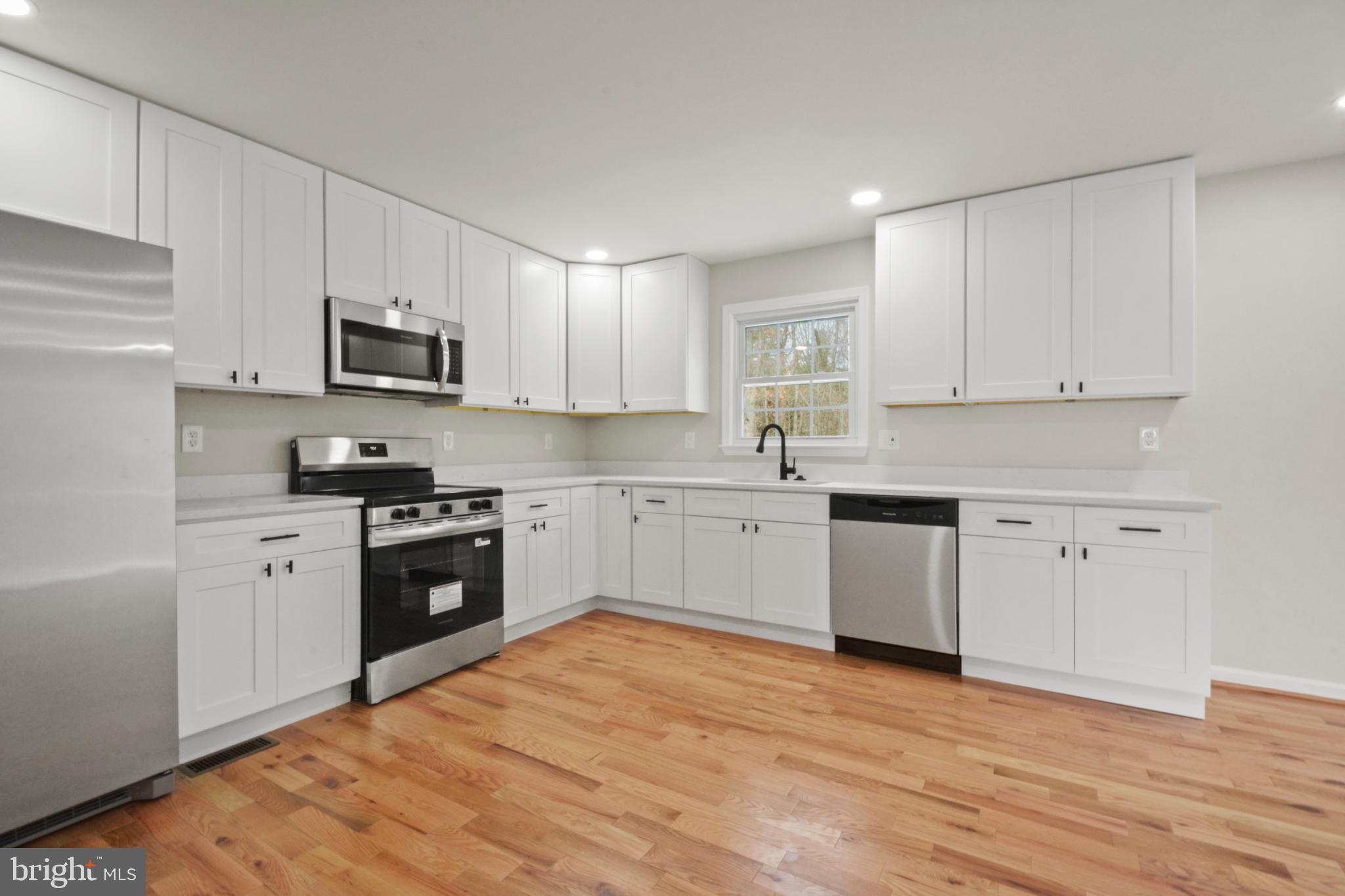 18487 Clay Hill Road Stevensburg, VA 22741 - Photo 20 of 41 a kitchen with granite countertop white cabinets and stainless steel appliances