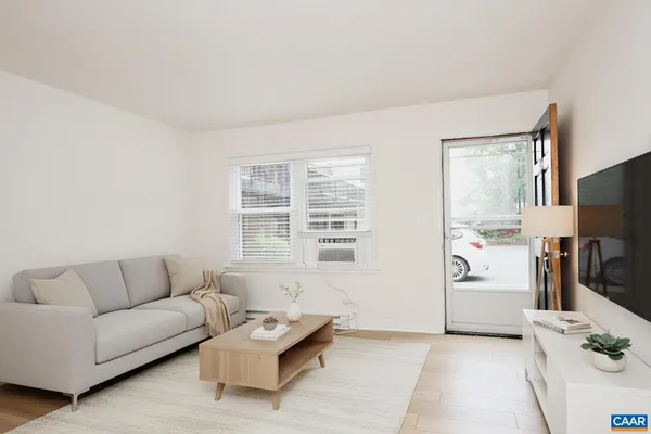 a living room with furniture a flat screen tv and a window