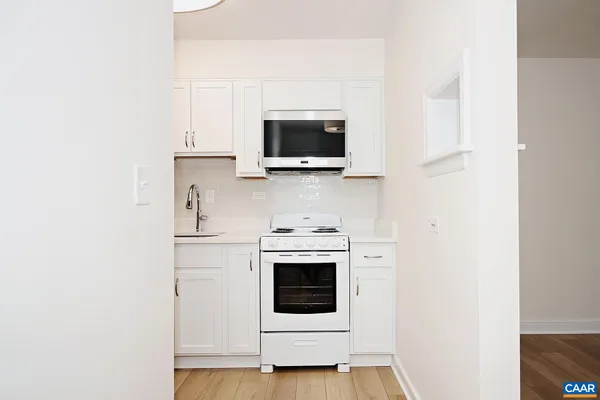 a living room with a stove and a microwave