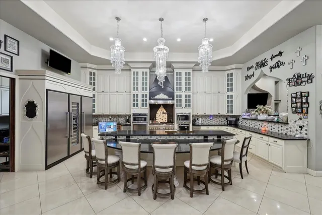 a kitchen with stainless steel appliances kitchen island granite countertop a table chairs and a refrigerator