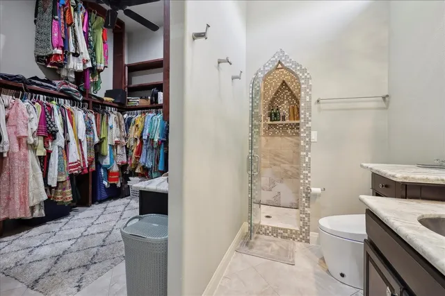 a view of walk in closet with clothes and shoes