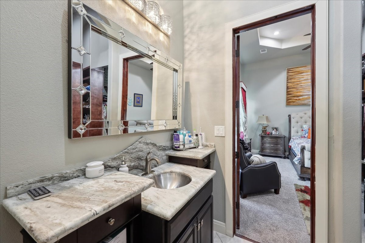 12460 Keith Road Beaumont, TX 77713 - Photo 24 of 40 a en suite bathroom with a granite countertop sink and a mirror
