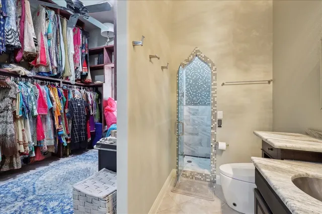 a view of walk in closet with clothes and shoes