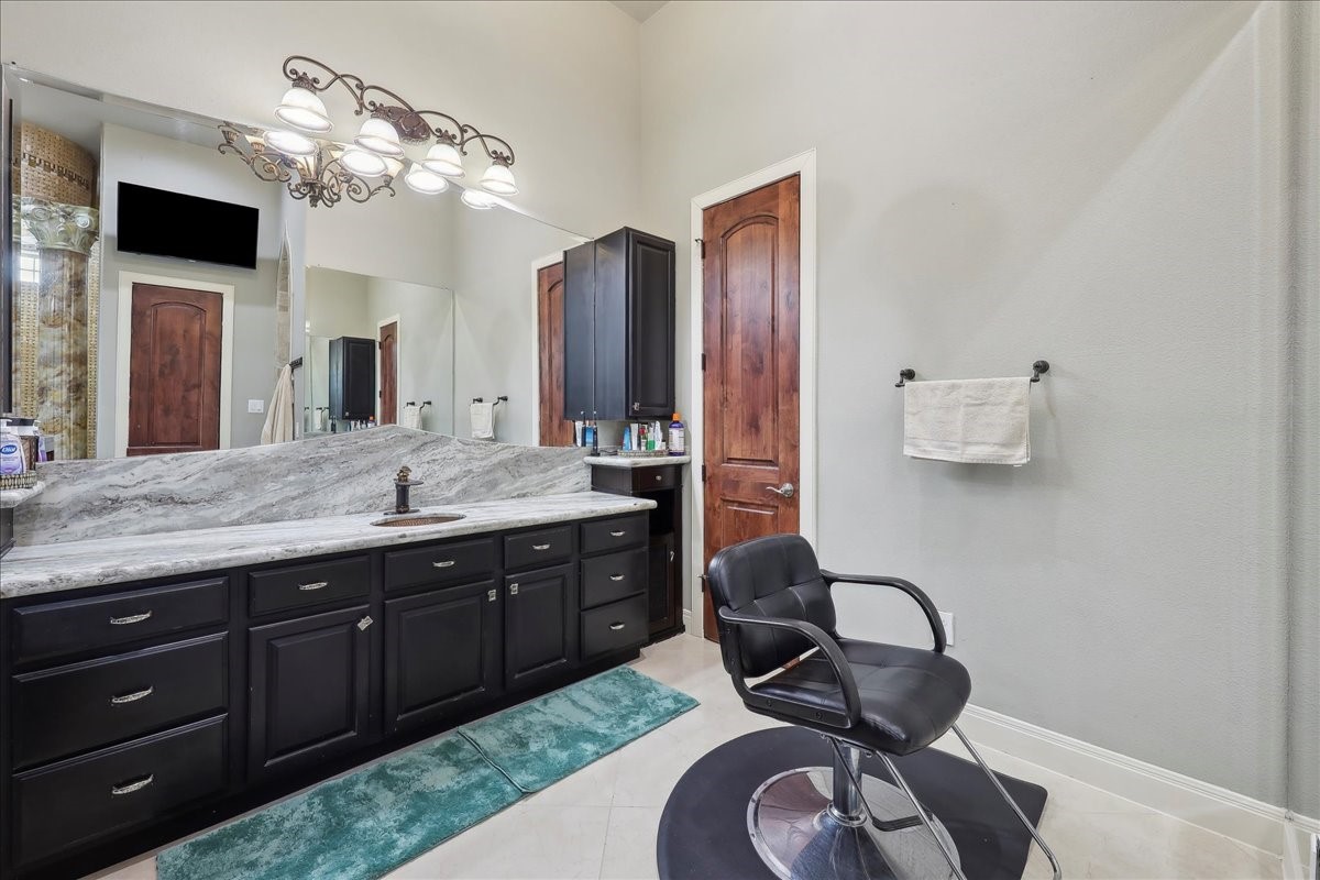 12460 Keith Road Beaumont, TX 77713 - Photo 33 of 40 a spacious bathroom with a granite countertop sink a mirror and vanity