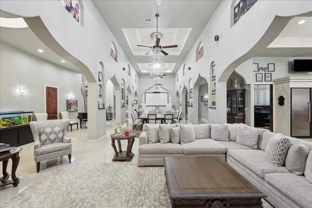 a living room with patio furniture and a chandelier