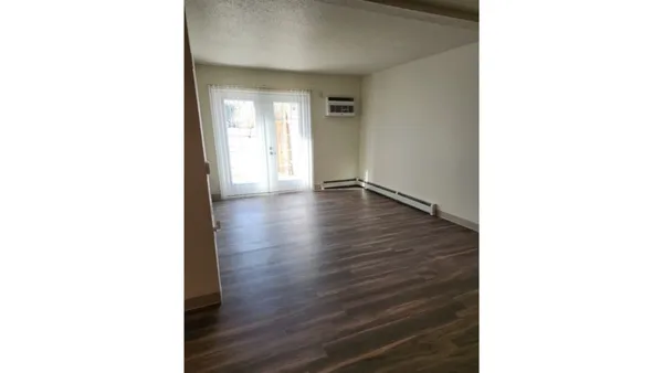 a view of an empty room with wooden floor