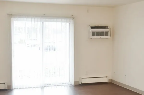 a view of a small space with wooden floor and a window