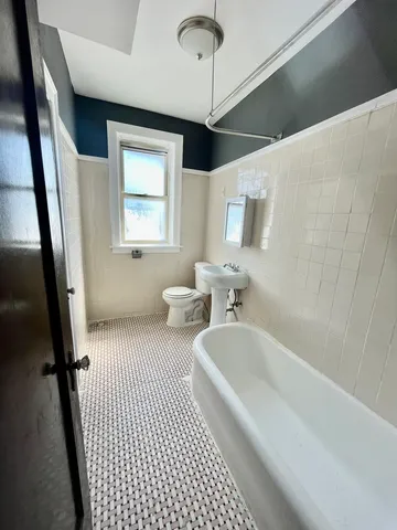 a bathroom with a tub sink and toilet