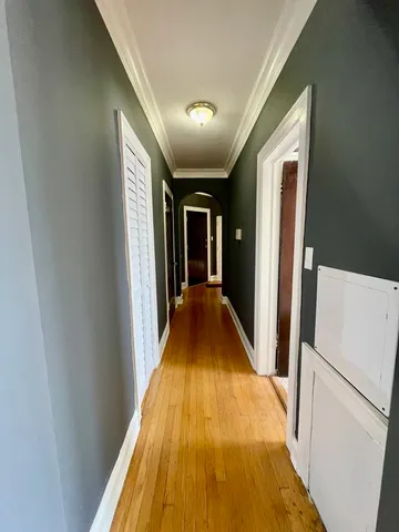 a view of a hallway with wooden floor and staircase