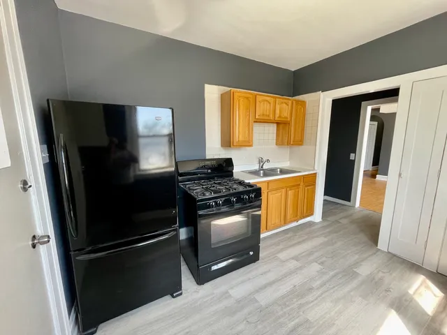 a kitchen with a stove refrigerator and a window