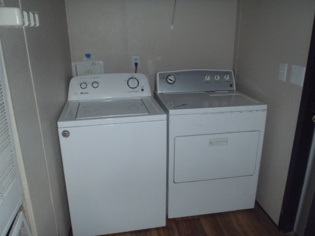 964 Railyard Drive Kyle, TX 78640 - Photo 25 of 25 Washroom featuring washing machine and clothes dryer, dark wood finished floors, and a heating unit