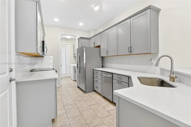 a kitchen with a refrigerator sink and cabinets
